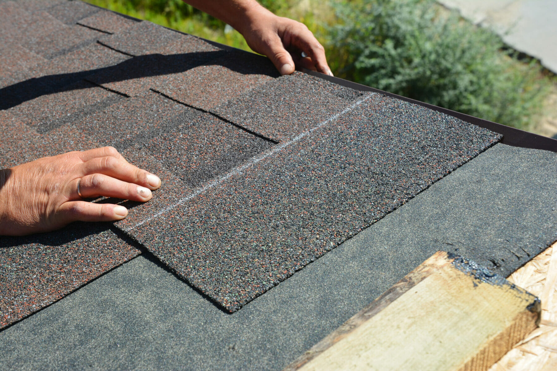 Asphalt Shingles Installation. Roofer Contractor Installing Asphalt Shingles on House Roofing Construction